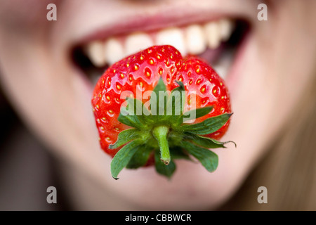 Close up di fragola per donna di bocca Foto Stock