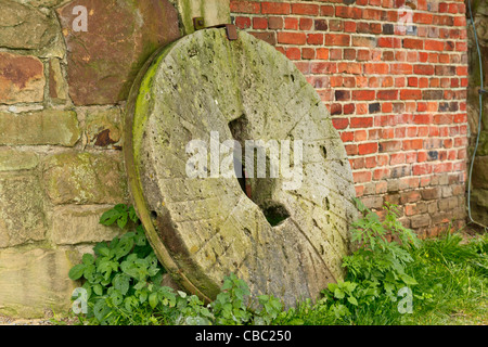 Pietra di mulino a lato dell'edificio Foto Stock