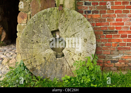 Pietra di mulino a lato dell'edificio Foto Stock