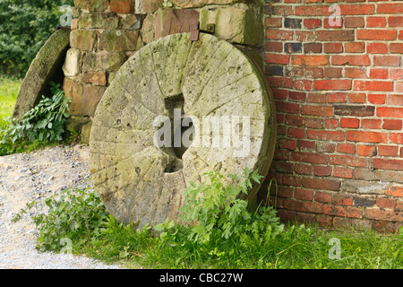 Pietra di mulino a lato dell'edificio Foto Stock