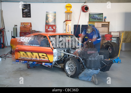 Appassionati lavorando su un drag racing Ford Mustang nel loro seminario garage. Foto Stock