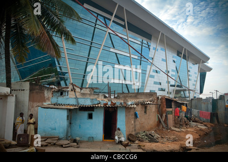Il famoso Infosys (Sistemi Info )edificio di vetro sopra visto abitazioni temporanee, Electronics City, Bangalore, Karnataka, India. Foto Stock
