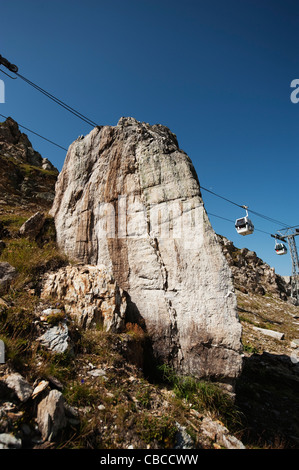 Funivie passando al di sopra di un dente grande del rock nelle alpi francesi in estate la luce del sole sopra Belle Plagne in Savoia, Francia Foto Stock