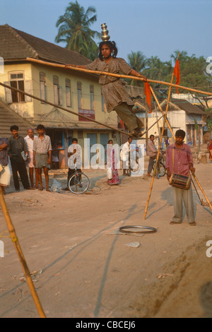 Ragazza giovane musicista di strada a piedi un funambolico, Thiruvanathapuram (Trivandrum), Kerala, India Foto Stock