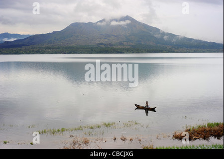 Uomo di pesca in un lago caldera del vulcano Batur. Batur è il vulcano più attivo sul popolare isola turistica di Bali Foto Stock