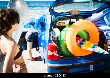 La donna lo scarico di giocattoli da spiaggia da auto Foto Stock