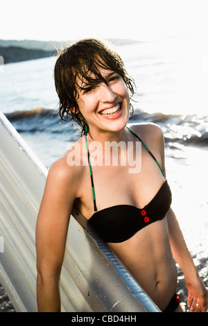 Donna con materasso gonfiabile sulla spiaggia Foto Stock