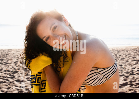 La donna la sua asciugatura capelli sulla spiaggia Foto Stock