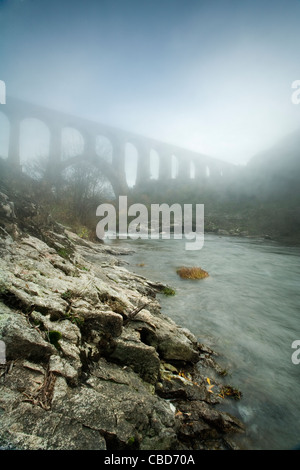 Nebbia rotolando su di rocky creek Foto Stock