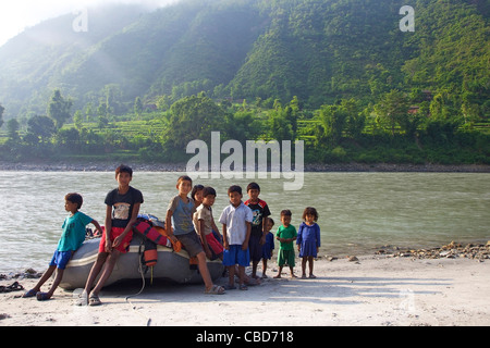 Il nepalese locale bambini seduti su zattera su Sun Kosi river, Nepal, Asia Foto Stock