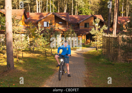 Un dodicenne ragazzo su una bici al di fuori delle ville di lusso a Center Parcs in Elveden vicino a Thetford , Inghilterra , Inghilterra , Regno Unito Foto Stock