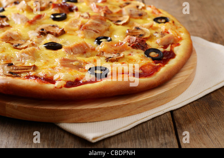 I funghi e il pollo pizza sul tagliere in legno closeup Foto Stock