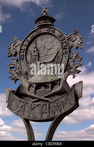 Ornati in metallo colato Oakham town segno con cielo blu dietro, Oakham, Rutland, England, Regno Unito Foto Stock