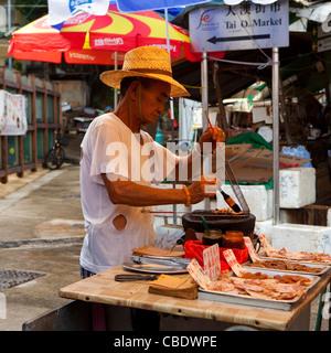 Venditore ambulante di vendita calamari fritti, Tai O Tanka tradizionale villaggio di pescatori, Hong Kong Cina, Asia Foto Stock