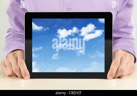 Imprenditore mostra digital tablet pc con cloudscape sullo schermo. Concetto di immagine su un cloud-computing tema. Foto Stock