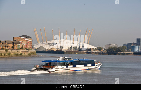 River bus accelerando lungo il Tamigi con 02 Arena e Isle of Dogs in background Londra Inghilterra Europa Foto Stock