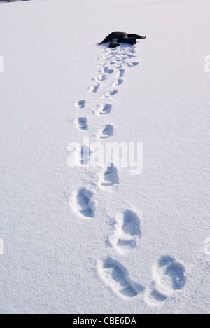 Stanco uomo nudi a giacere sulla neve Foto Stock