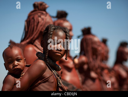 Ragazza Muhimba portando un bambino sulla schiena, villaggio di Elola, Angola Foto Stock