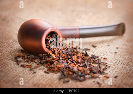 Tubo di fumo e tabacco sulla tela di lino sfondo Foto Stock