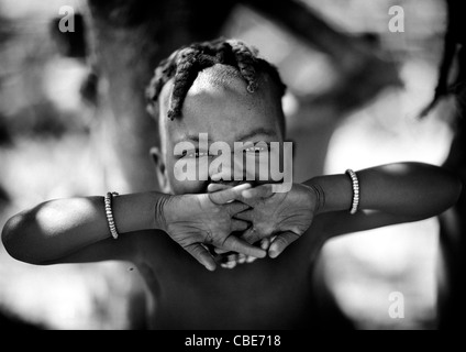 Ragazza Muhimba sbadigli Behin le mani, villaggio di Elola, Angola Foto Stock