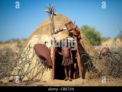 Ragazza Muhimba all'ingresso del suo rifugio, villaggio di Elola, Angola Foto Stock