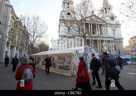 Pendolari e la gente di affari a piedi passato la protesta occupano al di fuori di St Pauls in Londra England Regno Unito Regno Unito Foto Stock