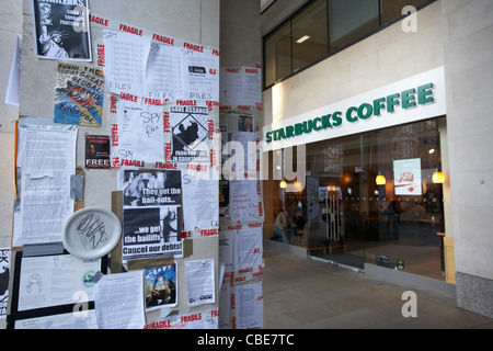 Anti bailout e cospirazione occupano manifesti di protesta al di fuori di Starbucks Londra Inghilterra Regno Unito Regno Unito Foto Stock