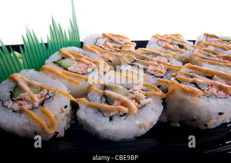 Close up di piccante california sushi rotoli su una piastra nera. Foto Stock