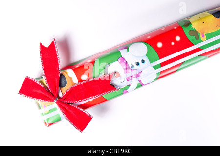 Una lunga rettangolare avvolto regalo di Natale con un velluto rosso di prua e nastro bianco. Foto Stock