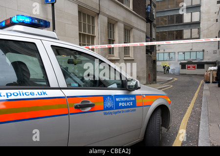 La Metropolitan Police squad automobile con la polizia cordone interno non cross nastro di segnalazione di incendi Londra Inghilterra Regno Unito Foto Stock