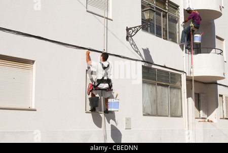 Due pittori in sistemi di cavi sbiancamento una parete in Portogallo Foto Stock