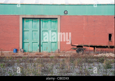 Verde porta di magazzino nel porto di Anversa/port Belgio e parete rossa. Foto Stock