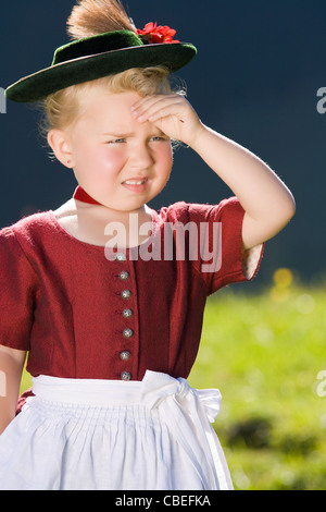 Piccola ragazza in un abito guarda nel paese Foto Stock