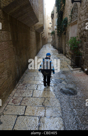 Ragazzo a piedi sotto la pioggia per le strade del quartiere ebraico. Gerusalemme vecchia città. Israele Foto Stock