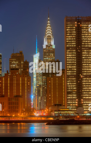 Il Chrysler building e altri edifici su 42nd Street nel cuore di Manhattan al crepuscolo in New York City. Foto Stock