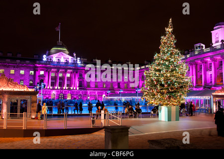 La Somerset House di Natale pista di pattinaggio sul ghiaccio con struttura ad albero e persone pattinaggio di notte Dicembre 2011 The Strand Londra Inghilterra REGNO UNITO Foto Stock