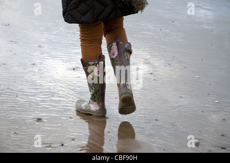 Una donna che indossa wellingtons di Fleetwood mentre si cammina un cane, Lanccashire, REGNO UNITO Foto Stock