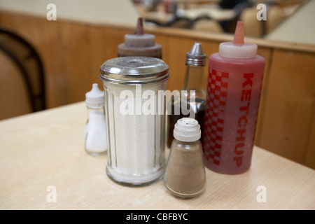 Condimenti salse e lo zucchero in una tabella in un cafe a Londra England Regno Unito Regno Unito Foto Stock