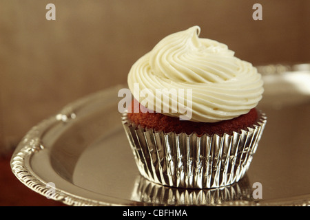 Ancora la vita di Red Velvet Cupcake con la glassa di formaggio cremoso è in tazza di lamina su un vassoio d'argento di spazio di copia Foto Stock