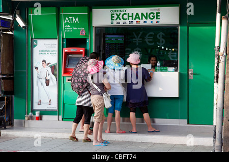 I turisti cambiando il denaro a un cambio valuta booth su Bangla Road a Patong Beach a Patong, Phuket, Tailandia Foto Stock