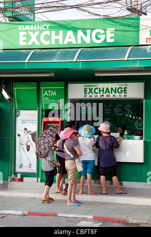 I turisti cambiando il denaro a un cambio valuta booth su Bangla Road a Patong Beach a Patong, Phuket, Tailandia Foto Stock