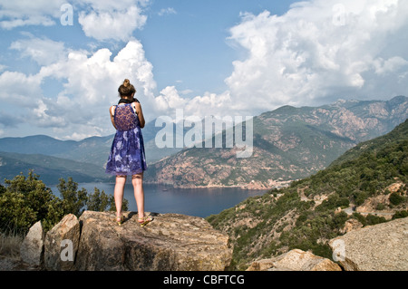 Un turista prende una foto del golfo di Porto da Les Calanches vicino alla città di Piana sulla costa occidentale dell'isola di Corsica, Francia meridionale. Foto Stock