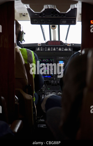 Pilota e co-pilota nella cabina di pilotaggio di un aereo, vista posteriore Foto Stock