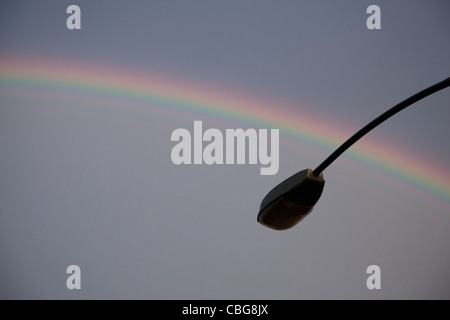 Un arcobaleno nel retro di un stagliano lampione Foto Stock