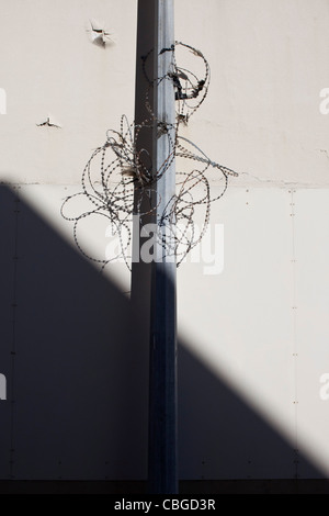 Lampione con filo spinato intorno ad esso Foto Stock