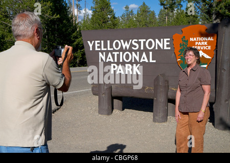 I turisti scattare una foto di fronte al Parco Nazionale di Yellowstone entrata SEGNO, West Yellowstone, Montana, USA. Foto Stock