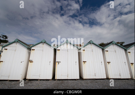 White cabine in legno lungo il lungomare di Budleigh Salterton, Devon contro un cielo blu Foto Stock