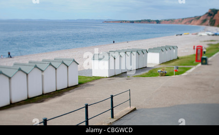 Colorate cabine in legno lungo il lungomare di Budleigh Salterton, Devon prese su una inclinazione obiettivo di cambio Foto Stock