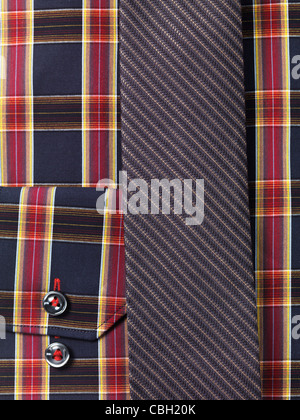Primo piano di una mens tartan maglietta a collare con un sottile cravatta sfondo astratto Foto Stock