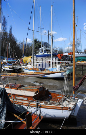 La colorata Vecchia barche di appoggio sul tidal velme in un cantiere. Foto Stock
